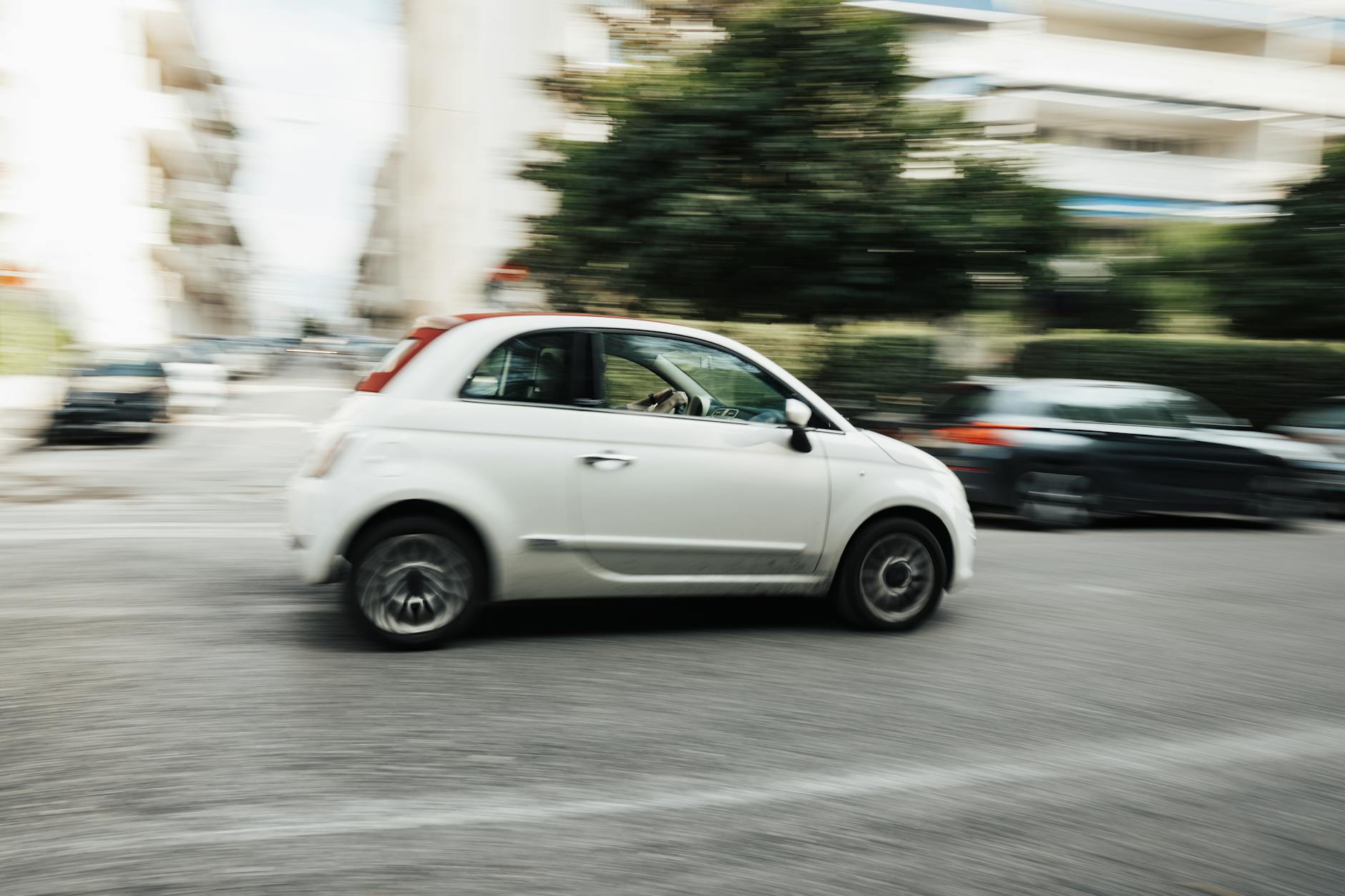 Biały Ford jedzie szybko po miejskiej ulicy z rozmytym tłem