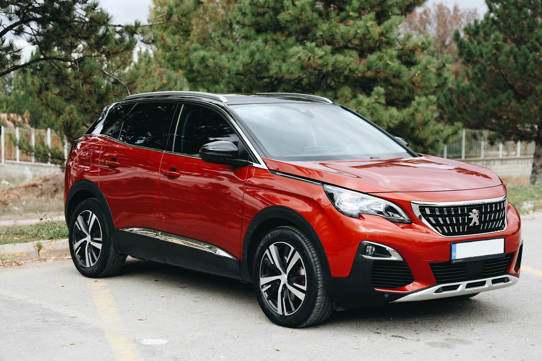 Czerwony SUV Hyundai Tucson zaparkowany na zewnątrz na tle drzew