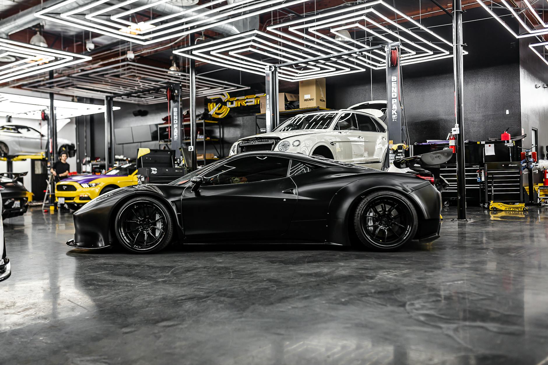 Czarny Aston Martin w luksusowym serwisie samochodowym